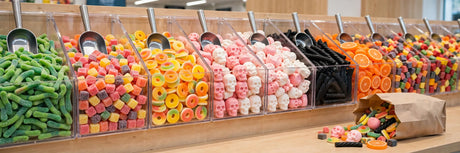 Swedish pick and mix candy bins with colorful sour gummies